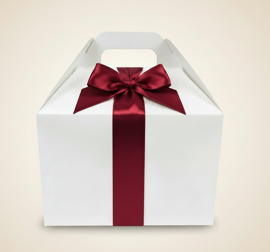 White gable box with deep red ribbon on light beige background
