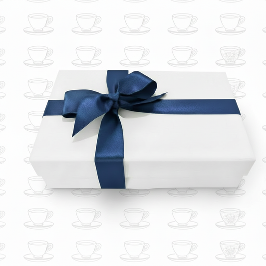 White gift box with navy ribbon on pure white teacup background